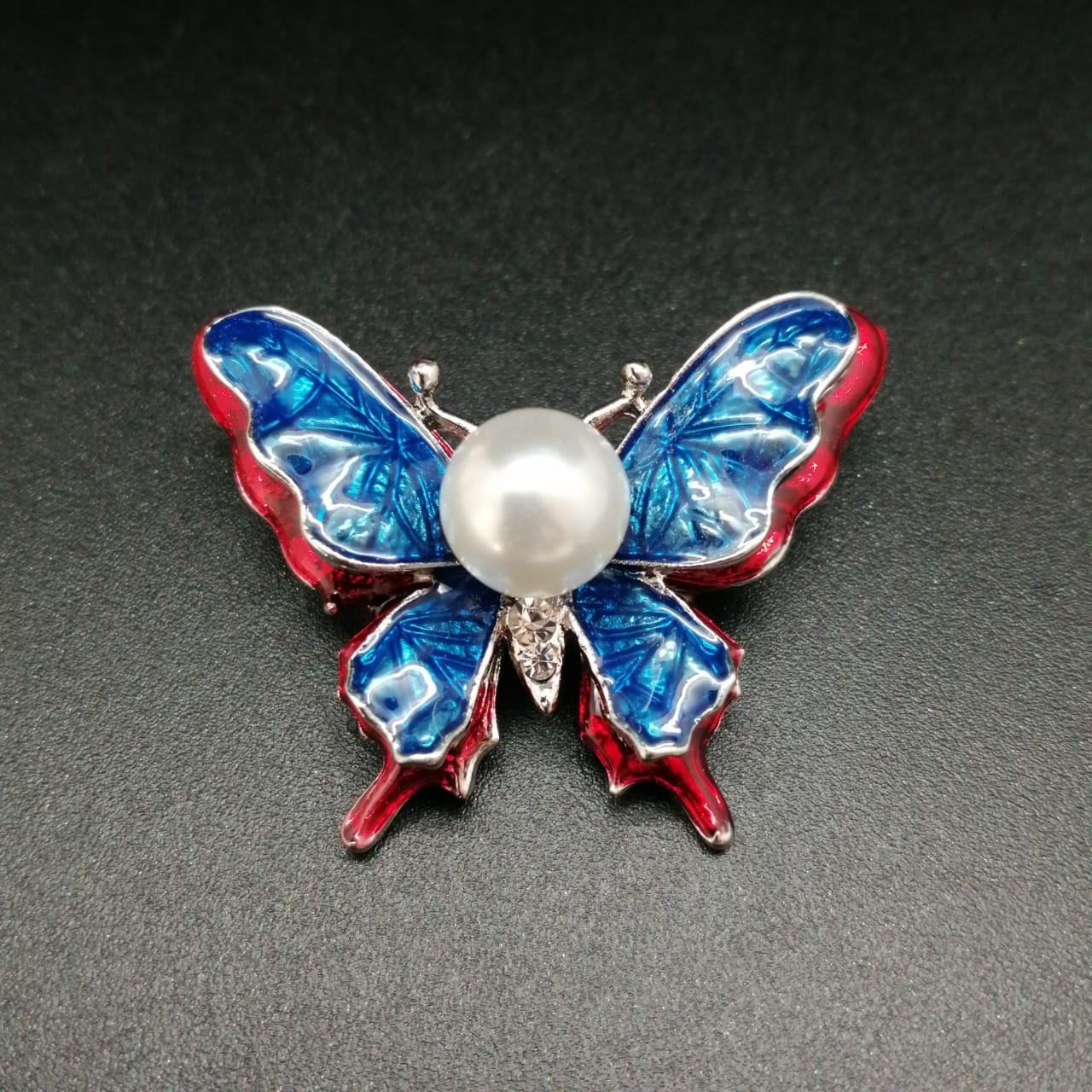 картинка Брошь бабочка с крыльями синего цвета с красной окантовкой от магазина El Corazon